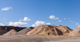 Piles of Gravel at Construction Site under Bright Blue Sky
